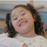 A girl smiles at the camera